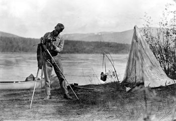 “Camera fiend takes a day off along the Yukon River. Rigging up the ‘tele’ lens. 1932”