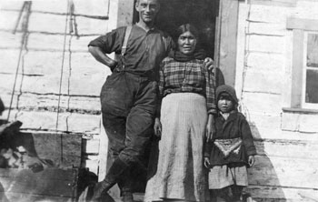 Claude Tidd posing with a First Nation woman and child, possibly at New Rampart House