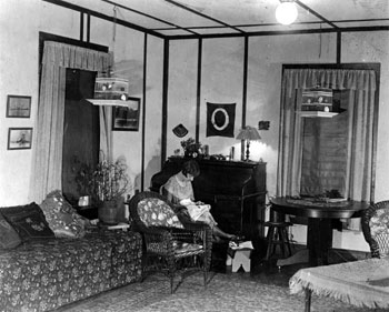 Mary sewing in the Mayo home. This is actually an experimental photo for Claude; his inscription reads: “Better luck here with help of Photo flood lamps – my first trial.”