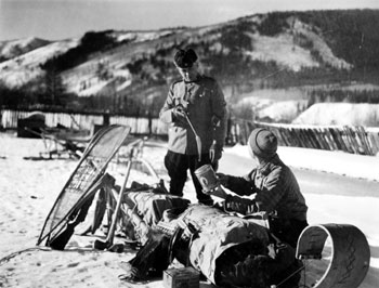 “The Mountie as Customs Officer.” RCMP Constable Joe Kessler questions a man on a customs matter. ca. 1938