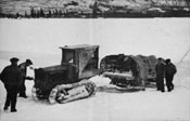 Jim “Spot Cash” Breaden and three other men standing by Breaden's caterpillar tractor with a sleigh hitched to it in Mayo. March 1934.