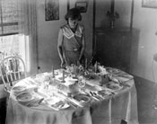 “Looks like a big night!” Mary sets the table for a dinner party, 1933.